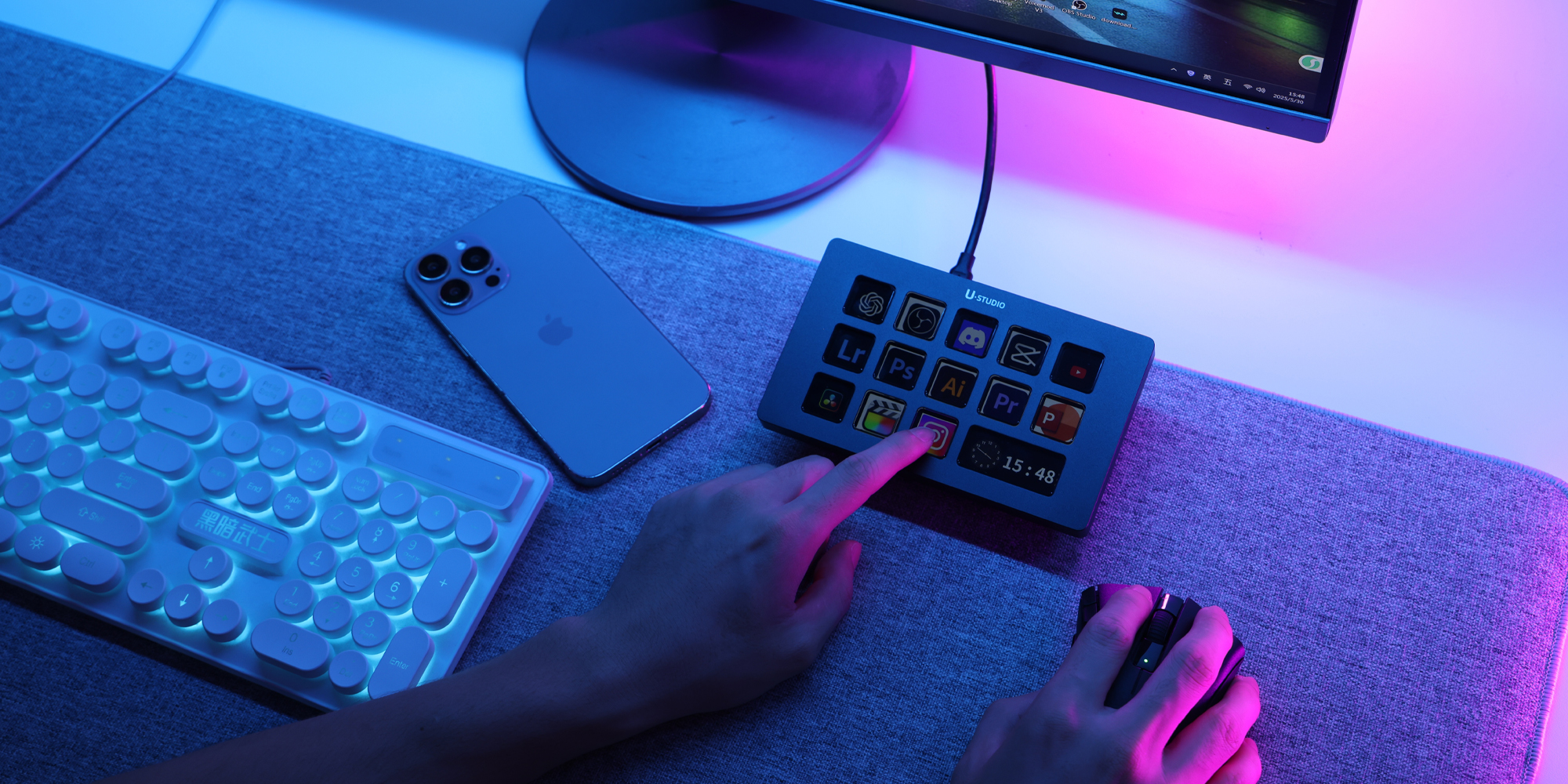 width=100% Konsola Ulanzi Stream Deck D200H ustawiona na podkładce na biurko obok smartfona i klawiatury obsługiwana palcem wskazującym